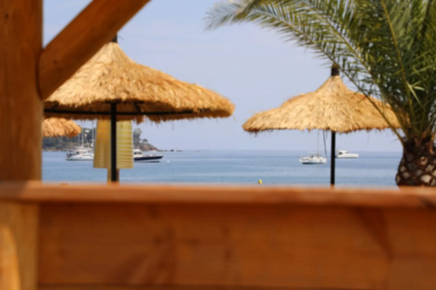 Parasols en paille et baie d'Agay depuis la terrasse