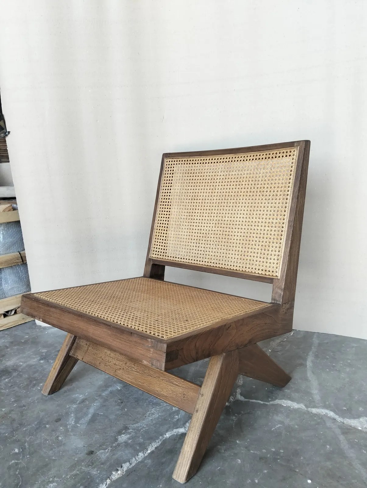 Fauteuil bas en teck et cannage, piètement croisé