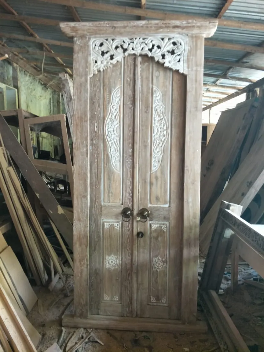Porte sculptée à fronton ajouré blanchi