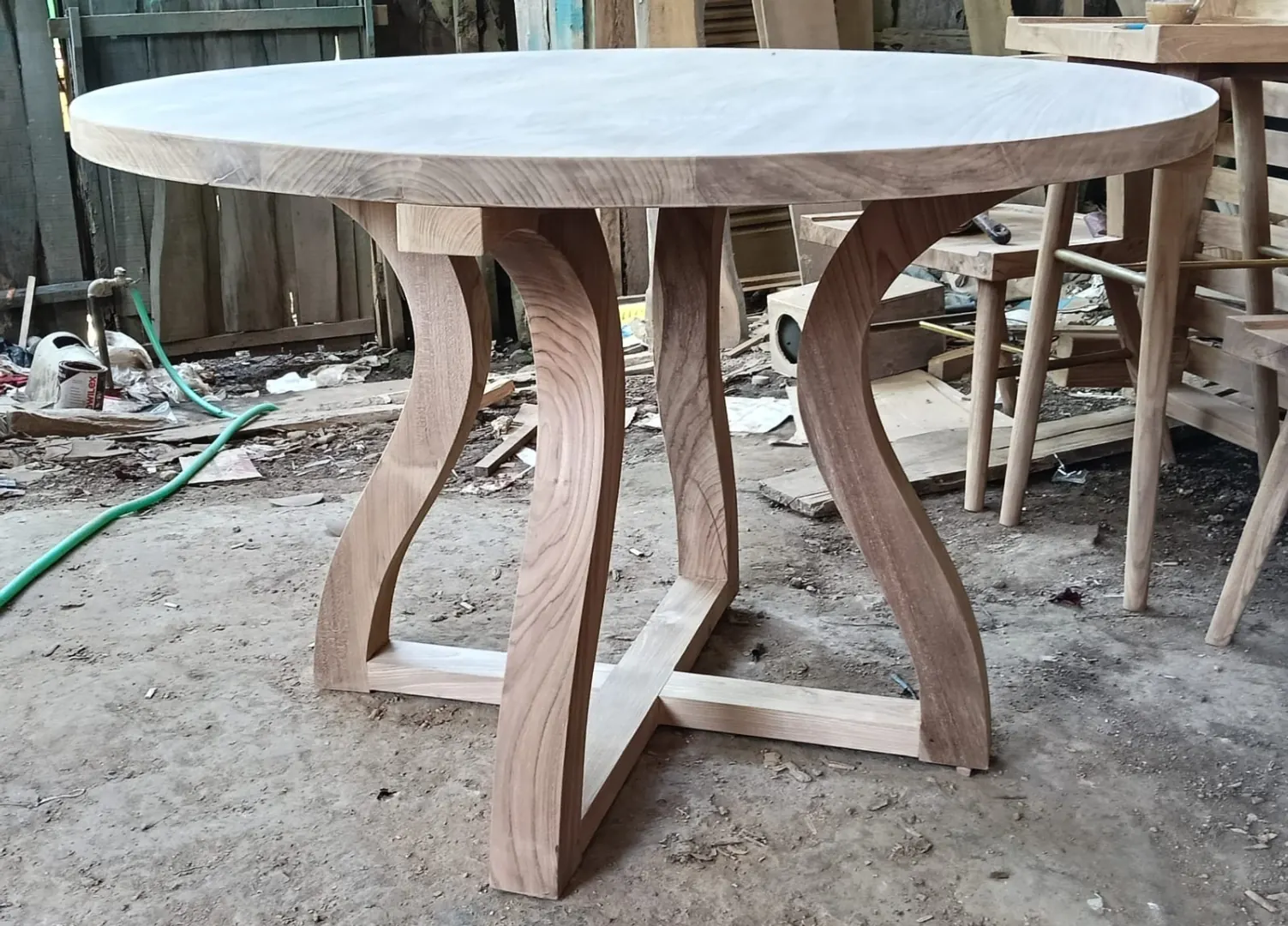 Table ronde en teck, piètement galbé